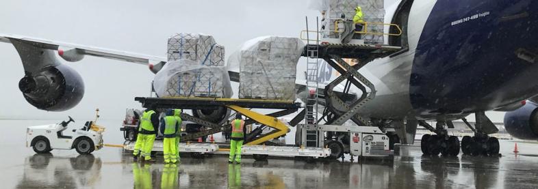 Staff loading shipping pallets on airplane
