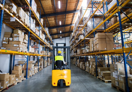 Warehouse worker using dolly inside warehouse