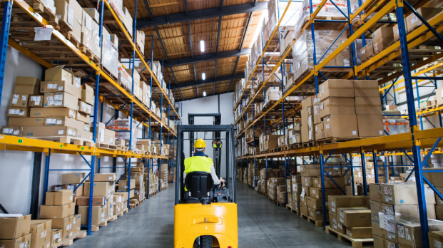 Warehouse worker using dolly inside warehouse