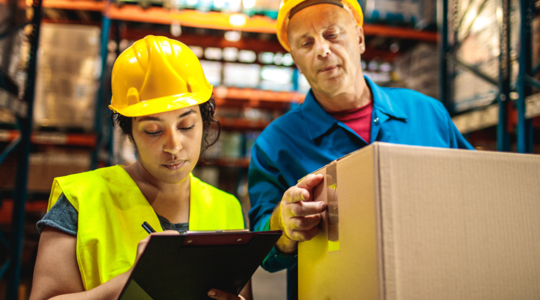 Warehouse workers with a tablet device and boxes